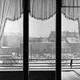 A snow scene looking out a window with ruffled curtains