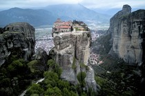 A Greek monastery, perched atop a narrow rock spire with steep cliffs all around.