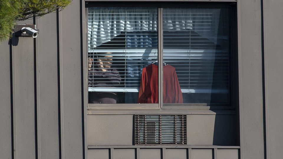 A resident looks through a window at a New Jersey nursing home.