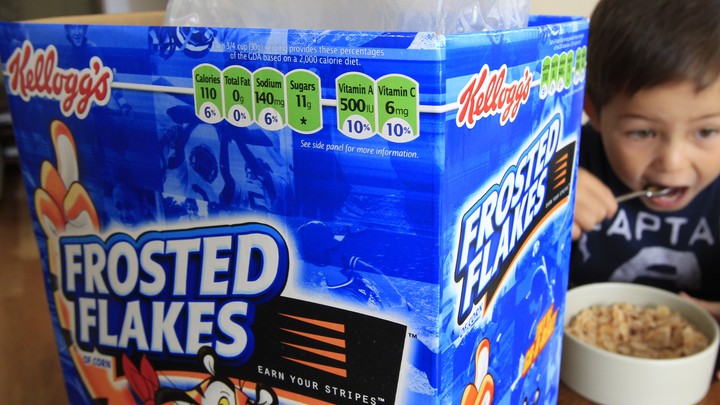 A child eats a bowl of Frosted Flakes.