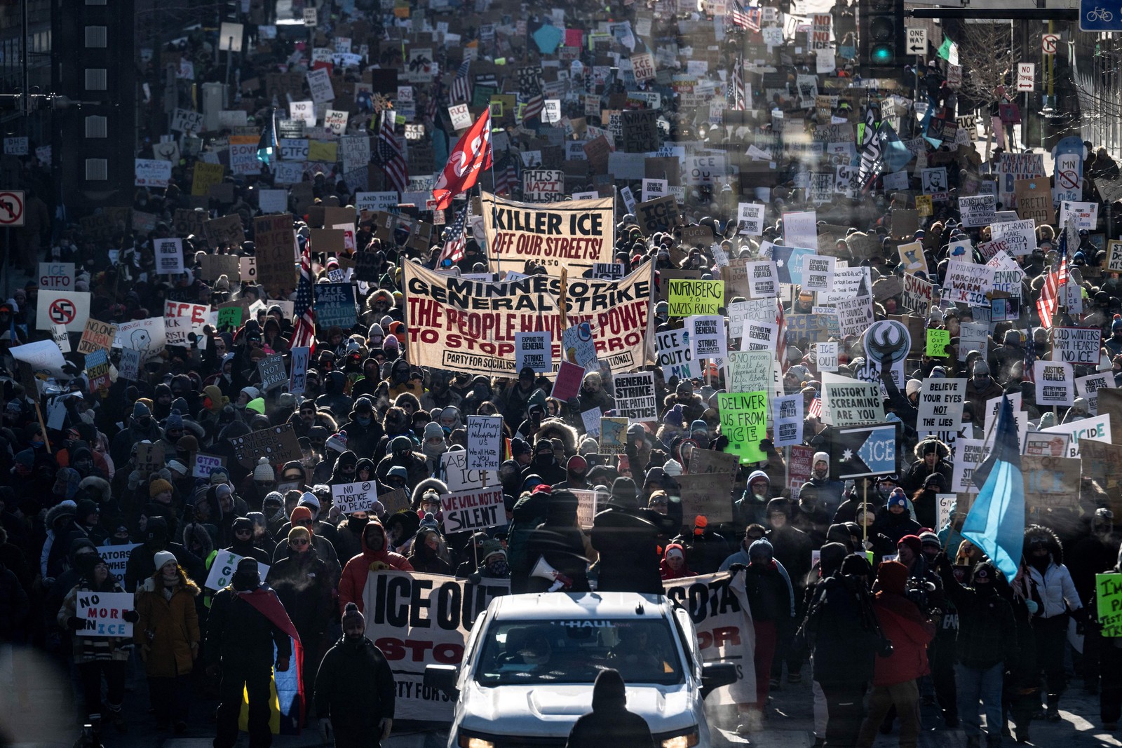 A large group of anti-ICE protesters march on a cold day.