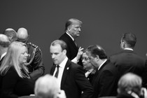 Black-and-white photo of Donald Trump in a roomful of people