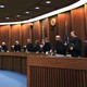 Justices in robes stand in a courtroom. 