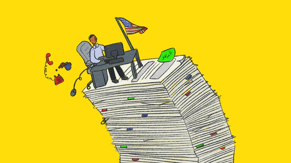 man sitting in an office desk on top of a stack of papers