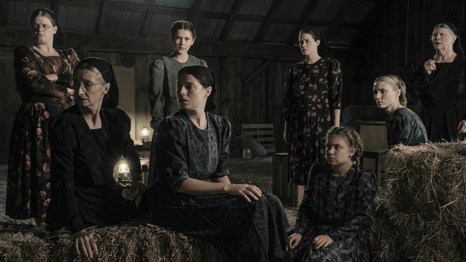 The ensemble of "Women Talking" gathered in a hayloft looking off-screen in the same direction