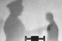 Photo of a wall with the shadows of two men in an execution room