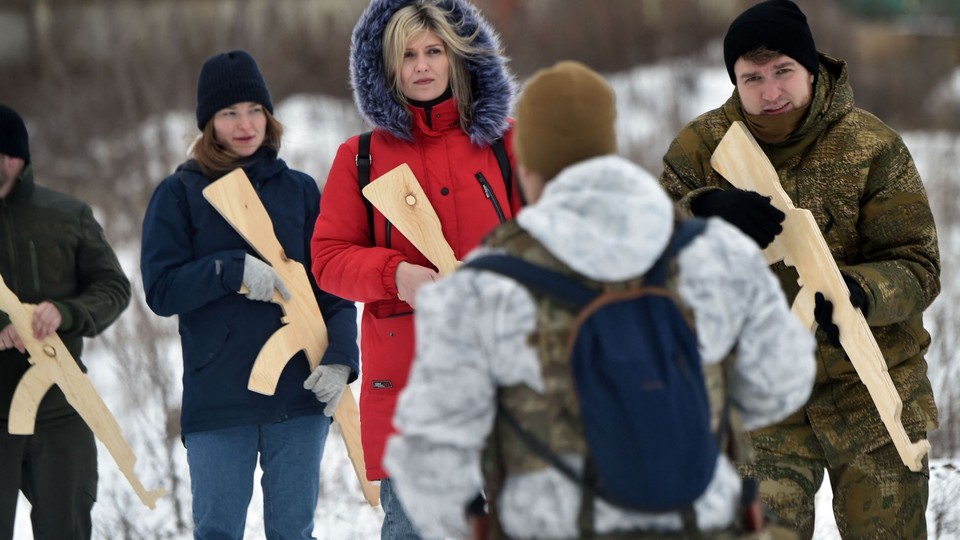 A military instructor teaches civilians holding wooden replicas of Kalashnikov rifles in Kyiv on February 6, 2022.