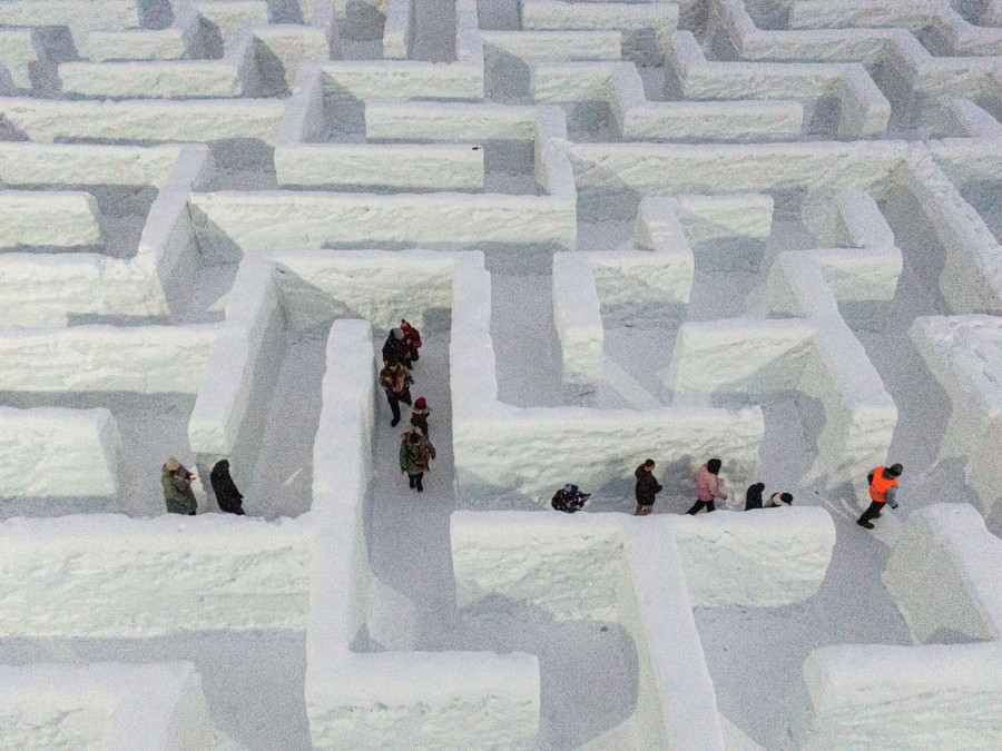 An aerial view of people trying to find their way out of an enormous snow maze