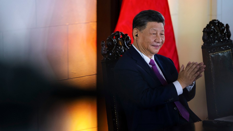 Photo of Xi Jinping sitting in a chair and applauding
