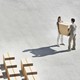 A man and a woman carrying a box together.