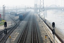 A photograph of cargo trains merging tracks in a foggy environment