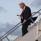 Photograph of Donald Trump walking down a staircase to exit an airplane