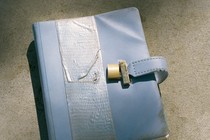a blue diary in the sun with duct tape around the cover