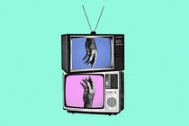Two stacked television with a hand in each screen reaching for the other