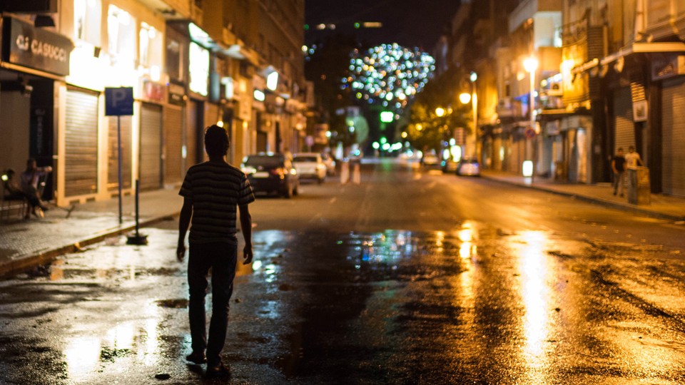 A person walks in the street at night in Syria