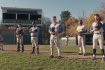 Baseball players stand in a field