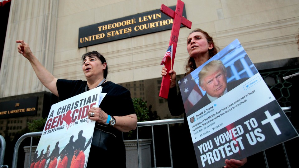 Protesters rally outside the federal court before a hearing to consider a class-action lawsuit filed on behalf of Iraqi nationals facing deportation, in Detroit, Michigan, June 21, 2017. 