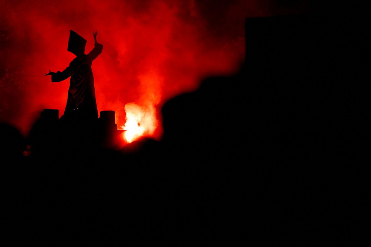 The silhouette of a spooky costumed figure above others during a parade