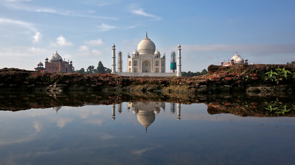 The Taj Mahal is reflected in a puddle.