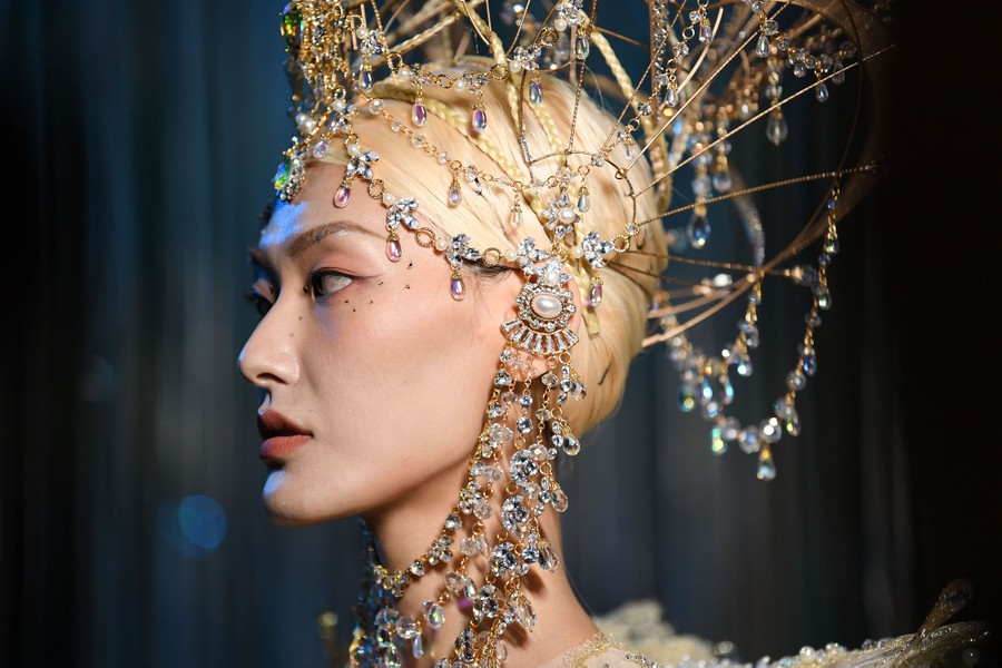 A model wears an ornate head covering.