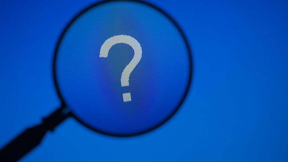 A magnifying glass hovers over a question mark