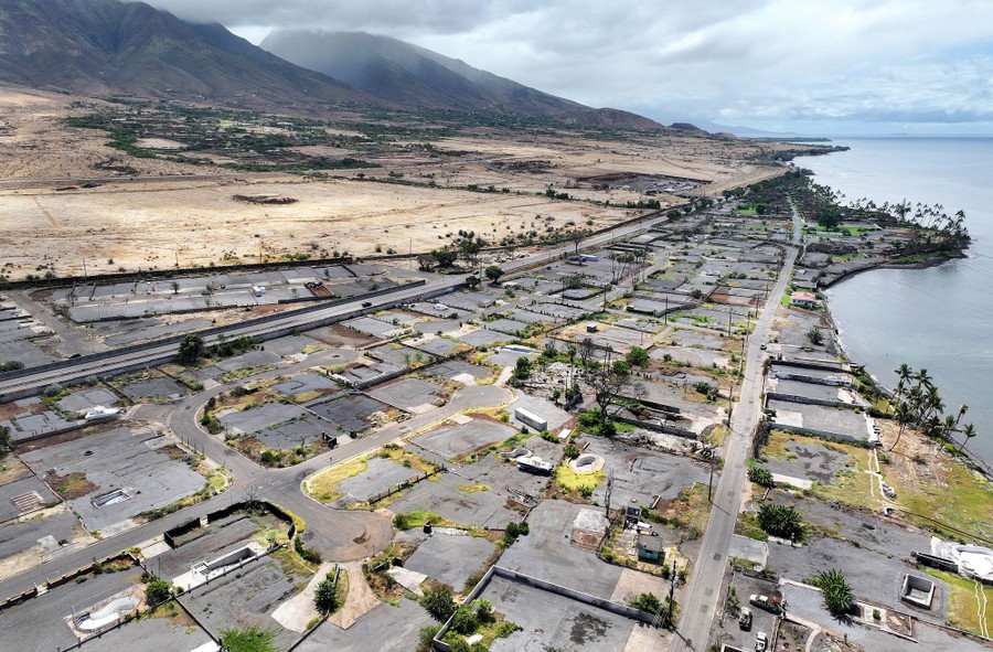 An aerial view of a residential neighborhood along a shoreline, with many empty lots