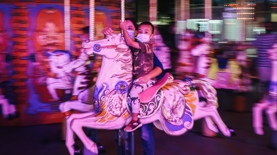A child and parent on a carousel.