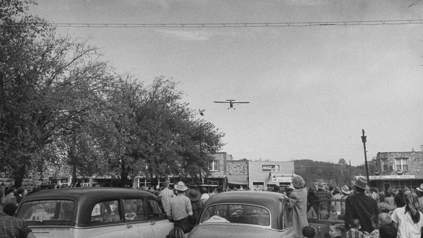 The 1953 turkey drop starts as the first bird is tossed from a low-flying plane.
