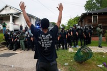 A demonstrator raises his hands in front of police in riot gear during protests in Baton Rouge, Louisiana, U.S., July 10, 2016. 