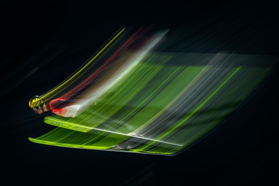 A blurred-motion view of a ski jumper in mid-air.