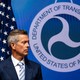 Sean Duffy stands in front of an American flag and a Department of Transportation logo