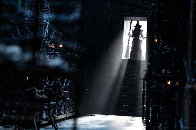 A still from Wicked: For Good showing a dark room with the shadow of a witch in a bright window