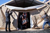 Workers take down an overflow patient care tent