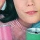 Vintage photograph of two young people smiling and holding colorful cans