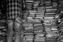 Man on ladder next to stacks of books