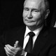 A black-and-white photo of Vladimir Putin clapping with a disinterested expression.