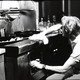A black-and-white photo of a man cleaning a kitchen