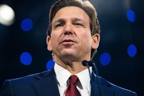 Ron DeSantis speaking to a microphone.