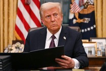 Photo of Donald Trump in the oval office signing the January 6 pardons