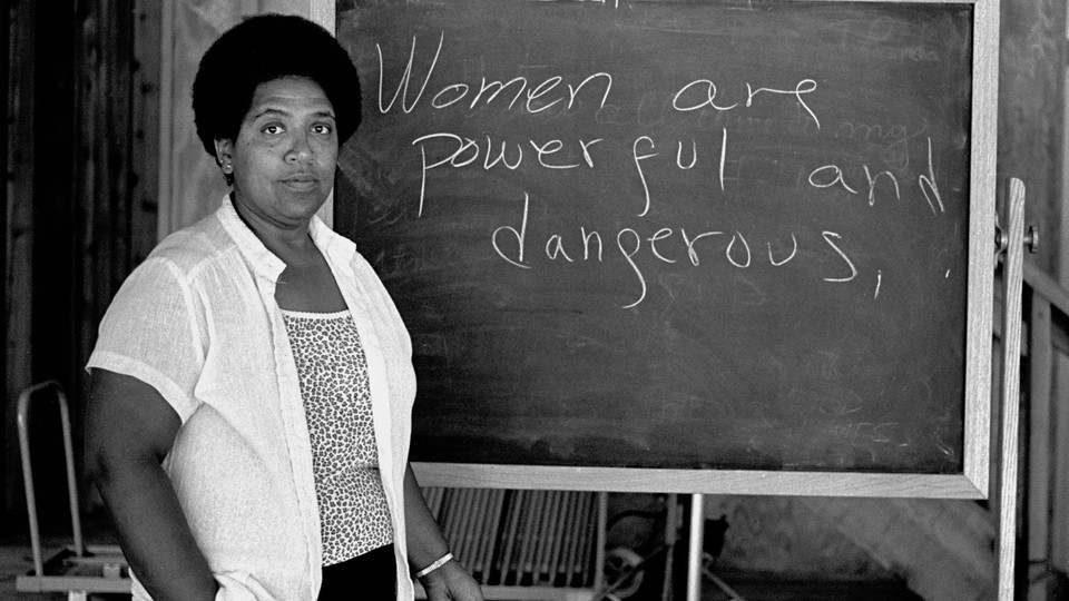 Audre Lorde in front of a blackboard that reads: "Women are powerful and dangerous."