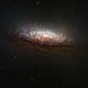 A telescopic view of a distant spiral galaxy dominated by thick lanes of dark dust