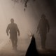 Two soldiers walk on a hazy dusty road