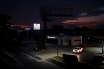 A truck with its headlights on in a dark Lovett Dental parking lot in Texas