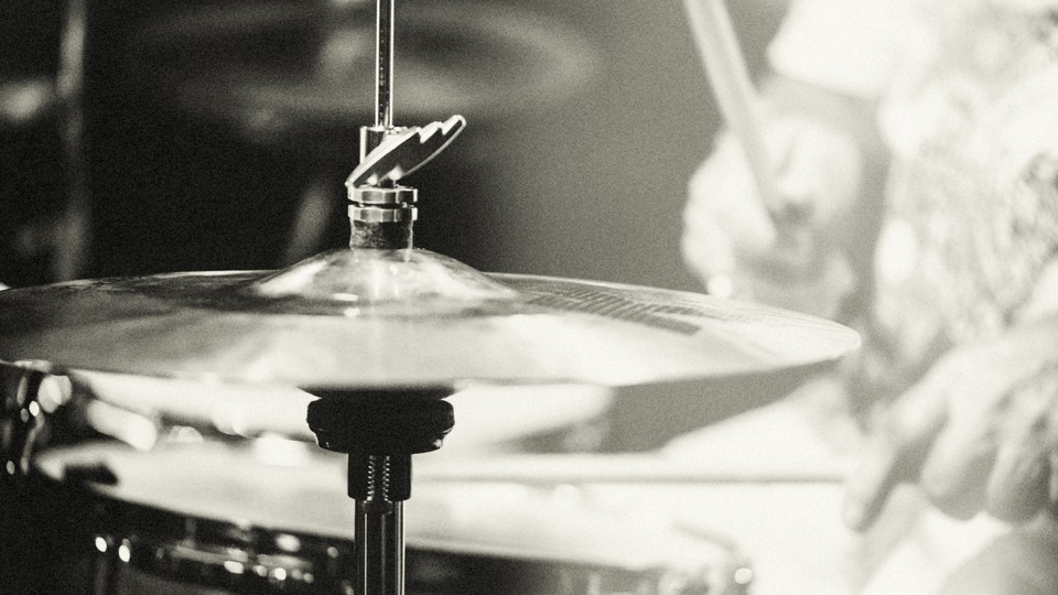 A black and white photo of a senior person playing the drums