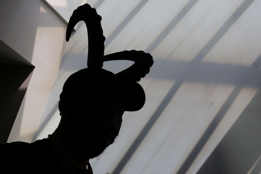 A person in silhouette wearing a hat with two long horns