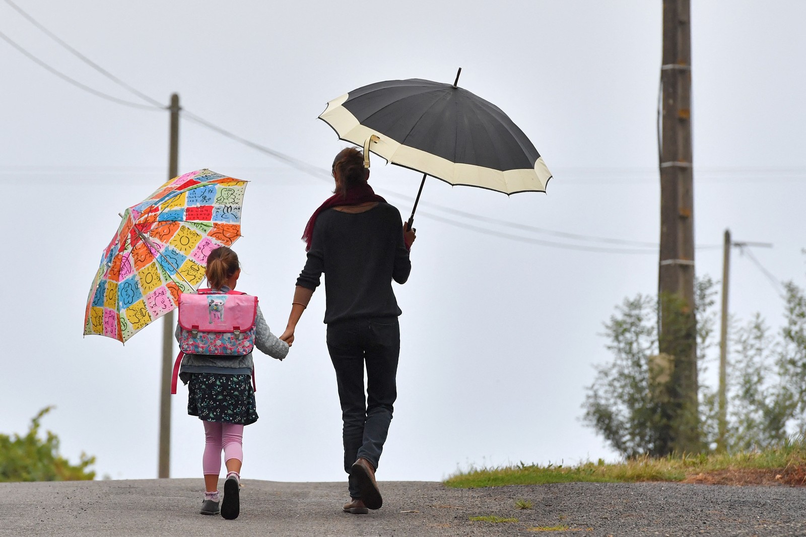 A mother walks her daughter to school.