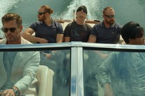 Chris Hemsworth drives a boat while wearing shades