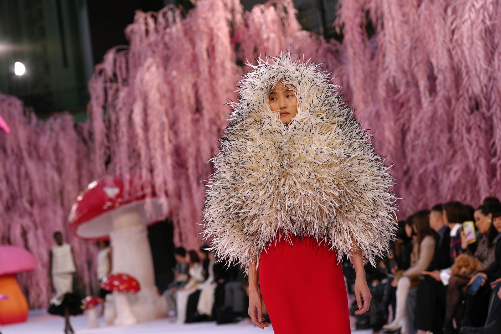 A model presents a very feathery garment during a fashion show.