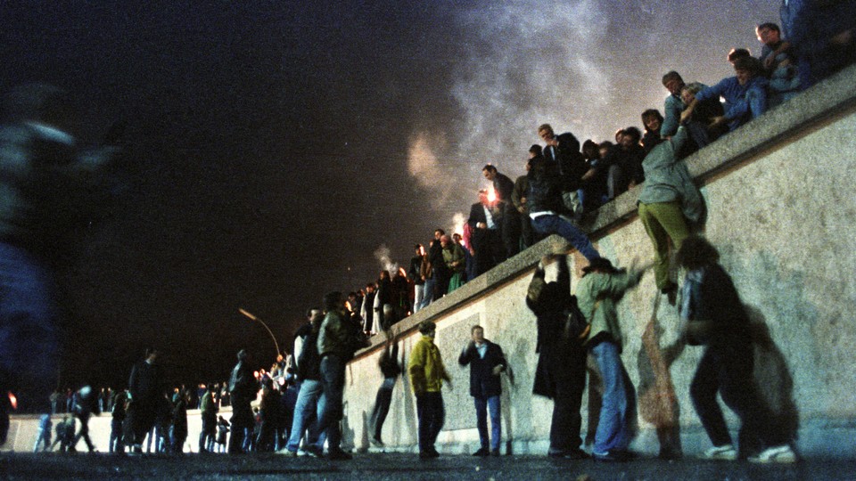 West Berliners help East Germans over the Berlin Wall.