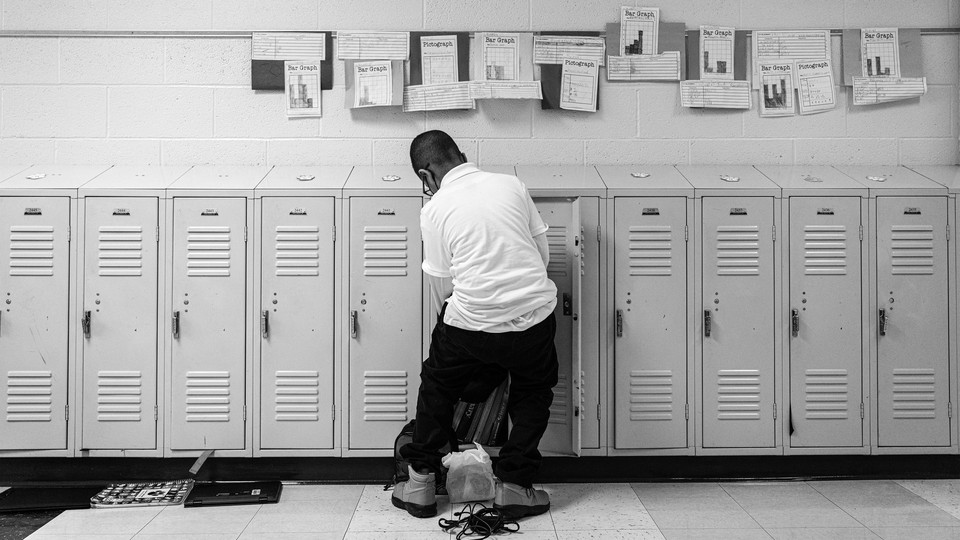A student goes through his locker in a hallway